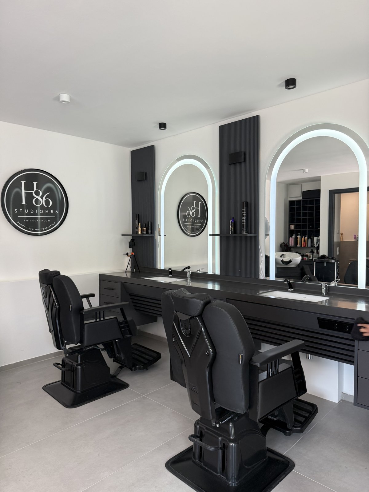 Innenansicht Studio H86 mit Stylingplätzen und Logo